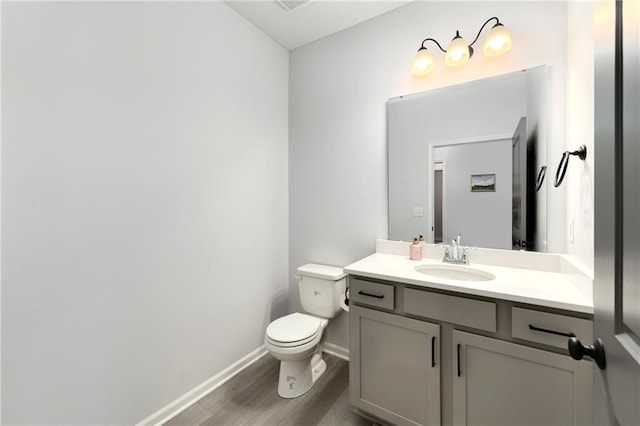 bathroom with vanity, hardwood / wood-style flooring, and toilet