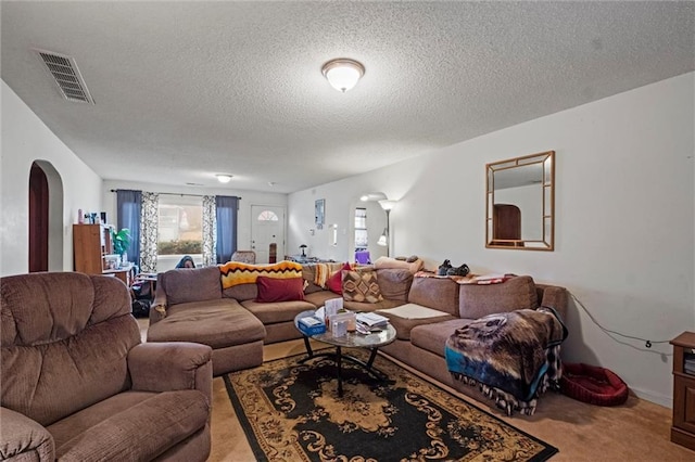 carpeted living room featuring a textured ceiling