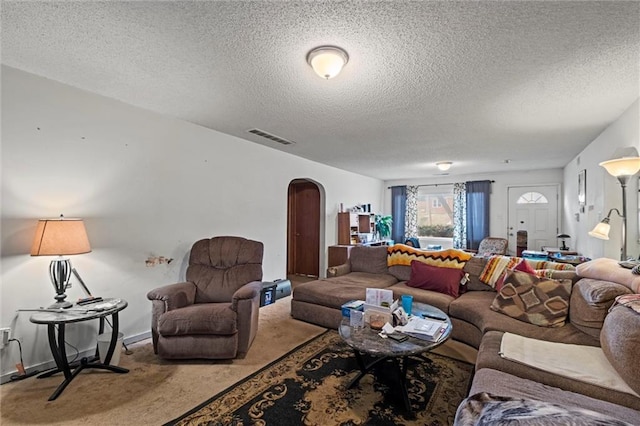 carpeted living room featuring a textured ceiling