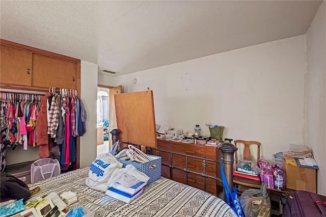 bedroom with a textured ceiling and a closet