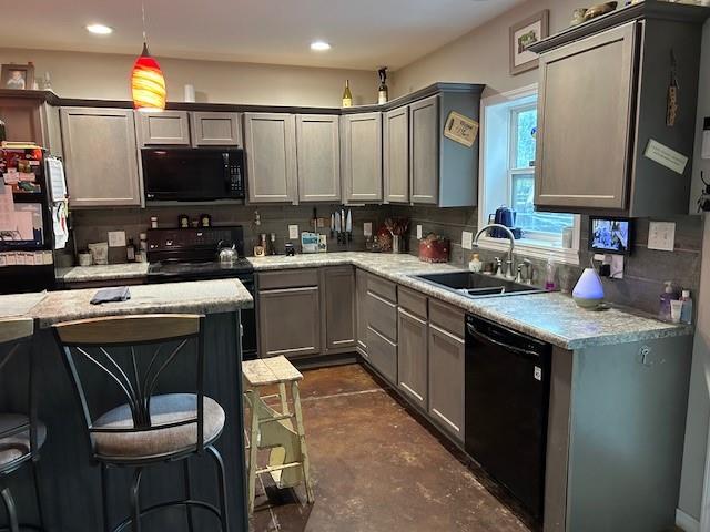 kitchen featuring pendant lighting, sink, tasteful backsplash, gray cabinetry, and black appliances