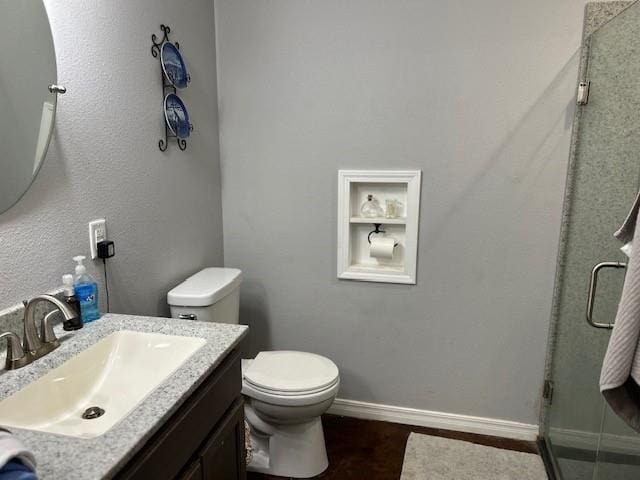 bathroom with walk in shower, vanity, and toilet