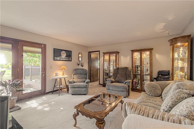 living room with ornamental molding and light colored carpet