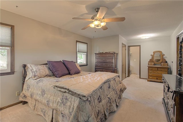 carpeted bedroom featuring ceiling fan and multiple windows