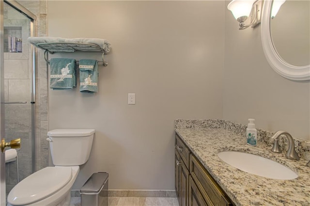 bathroom featuring toilet, an enclosed shower, and vanity