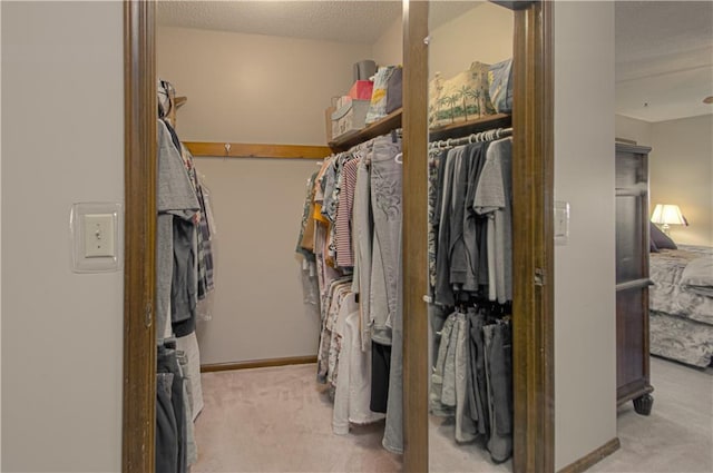 walk in closet featuring light colored carpet