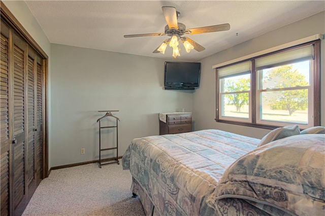 bedroom with a closet, ceiling fan, and light colored carpet