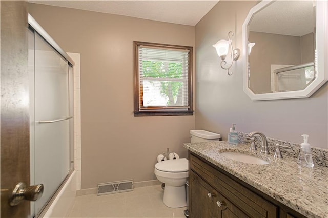 full bathroom with toilet, bath / shower combo with glass door, vanity, and tile patterned flooring