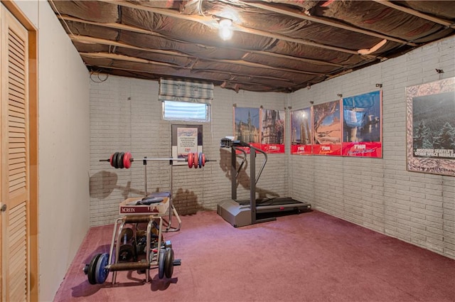 workout area featuring brick wall and carpet