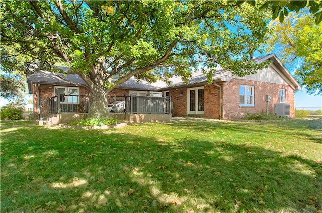 back of property featuring cooling unit and a yard