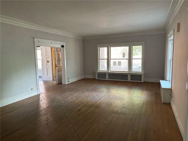 spare room featuring crown molding, dark hardwood / wood-style flooring, and radiator heating unit