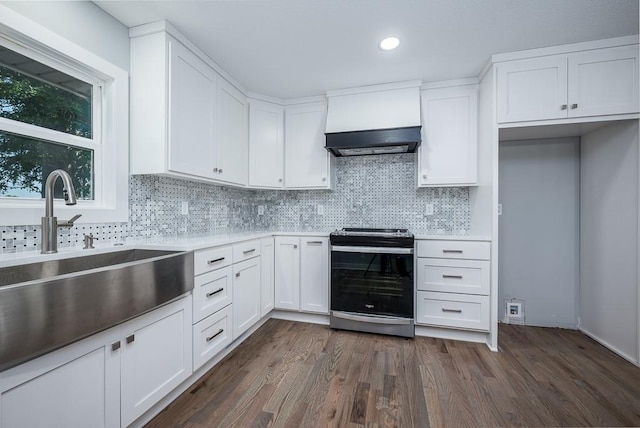 kitchen with decorative backsplash, white cabinetry, dark hardwood / wood-style floors, and stainless steel stove