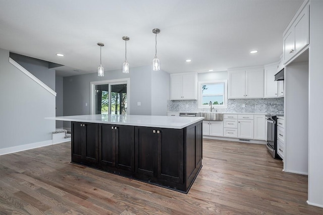 kitchen featuring white cabinets, stainless steel electric stove, and a kitchen island