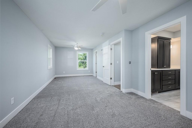 carpeted spare room with ceiling fan