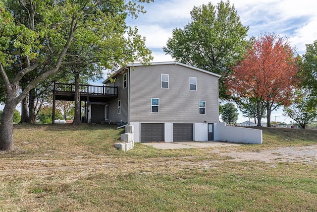 view of side of property with a garage, a lawn, and a wooden deck