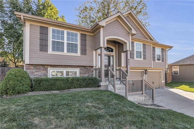 split foyer home with a garage and a front lawn