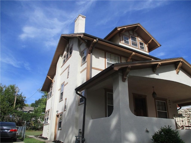 view of home's exterior with a chimney and stucco siding