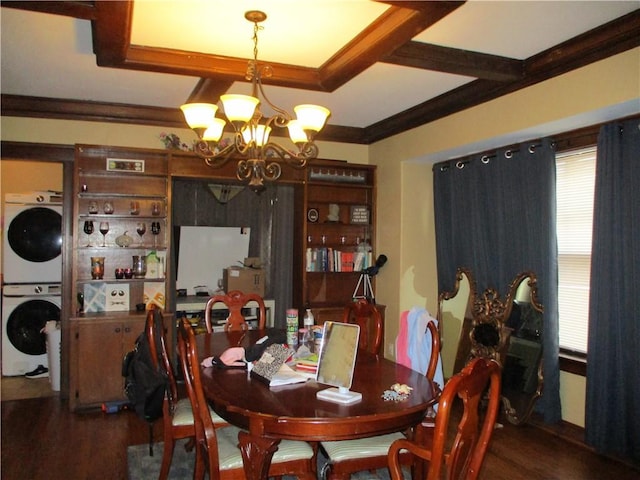 dining space with stacked washer and dryer, a notable chandelier, ornamental molding, and dark hardwood / wood-style floors