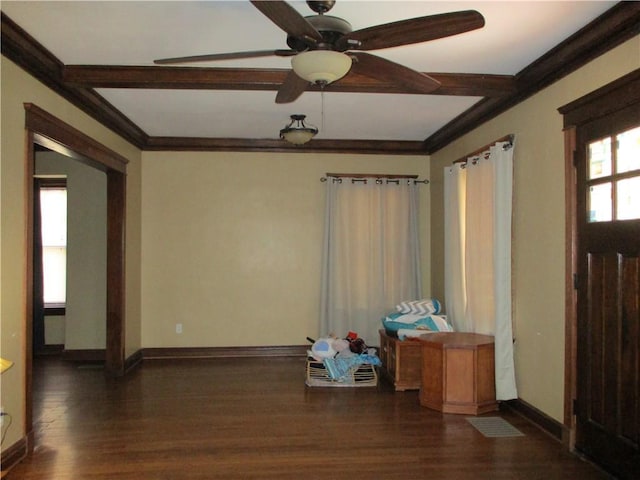 spare room featuring baseboards, beamed ceiling, wood finished floors, and ornamental molding