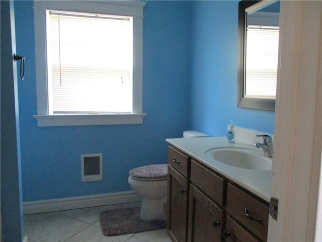 bathroom with toilet, plenty of natural light, visible vents, and vanity