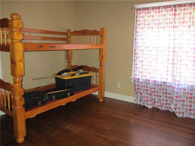 bedroom featuring baseboards and wood finished floors