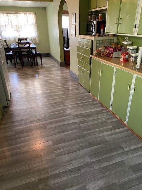 kitchen featuring refrigerator, green cabinets, and dark hardwood / wood-style flooring