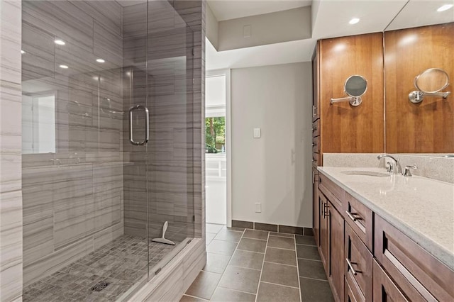 bathroom with a stall shower, vanity, and tile patterned floors