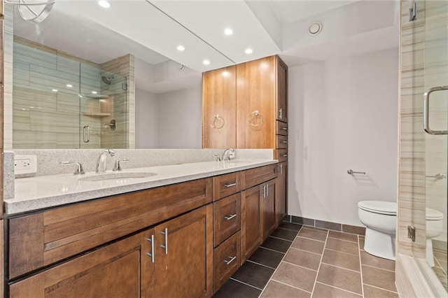 full bath with double vanity, a sink, toilet, and tile patterned floors