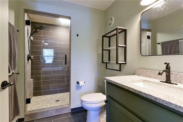 bathroom featuring vanity, tile patterned flooring, toilet, and an enclosed shower