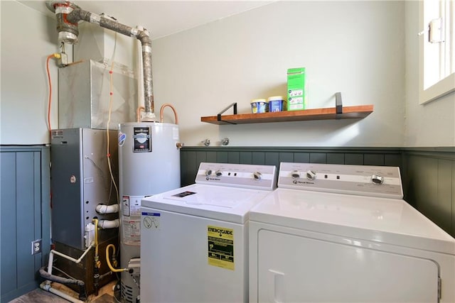 clothes washing area featuring separate washer and dryer and water heater