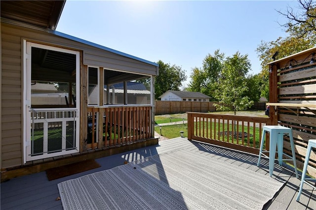 deck with a yard and a sunroom