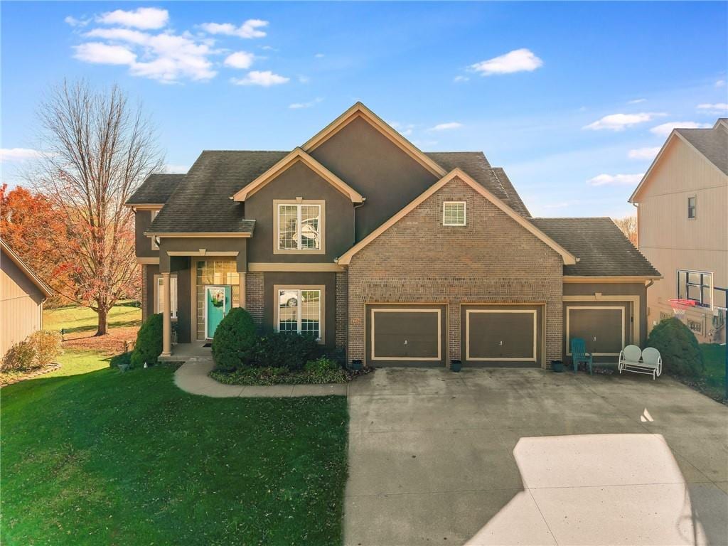 9003 NE 91st Ter, Kansas City, MO 64157 - traditional home with concrete driveway, brick siding, a front yard, and an attached garage