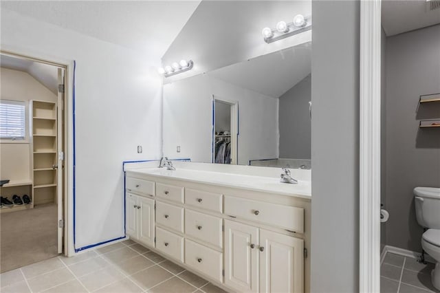 bathroom with lofted ceiling, tile patterned floors, toilet, and vanity