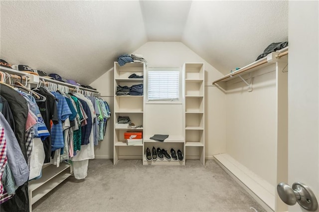 walk in closet featuring light carpet and vaulted ceiling