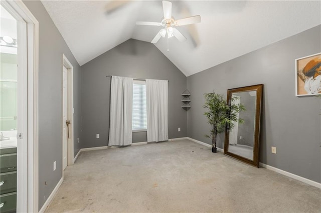 unfurnished bedroom featuring connected bathroom, vaulted ceiling, light carpet, and ceiling fan