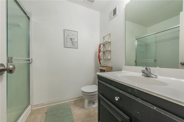 bathroom featuring tile patterned flooring, vanity, toilet, and a shower with door