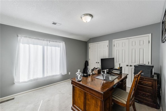 home office featuring lofted ceiling, a textured ceiling, and light carpet