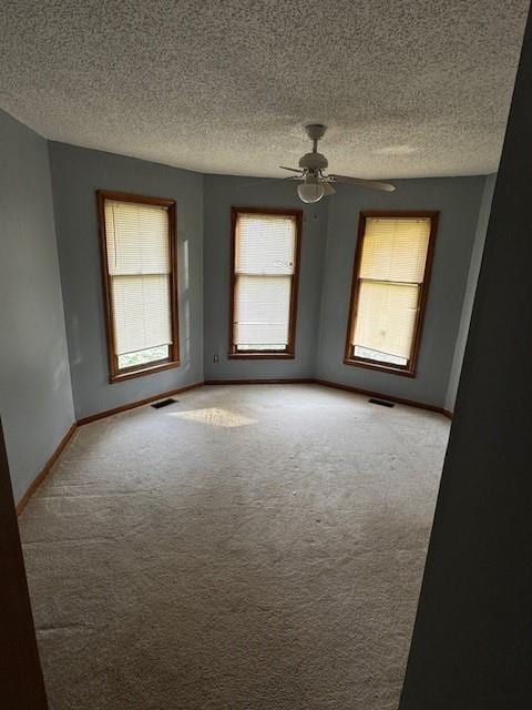 spare room featuring ceiling fan, a textured ceiling, and carpet flooring