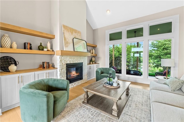7016 N Polk Ave, Kansas City, MO 64151 - living room featuring a stone fireplace, high vaulted ceiling, and light wood-style floors