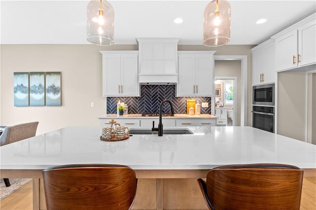 7016 N Polk Ave, Kansas City, MO 64151 - kitchen with stainless steel oven, a sink, backsplash, an island with sink, and built in microwave