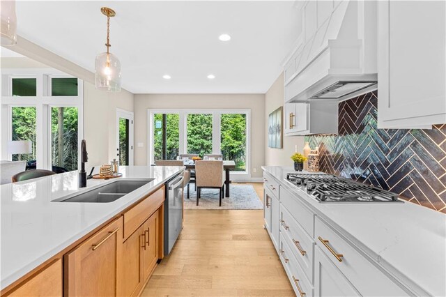 7016 N Polk Ave, Kansas City, MO 64151 - kitchen with a sink, custom exhaust hood, stainless steel appliances, light countertops, and recessed lighting