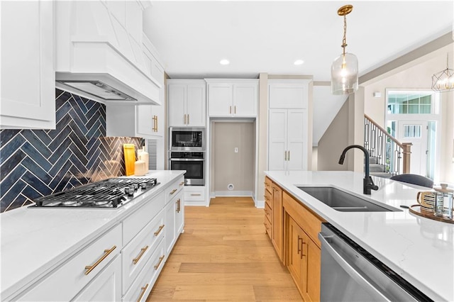 7016 N Polk Ave, Kansas City, MO 64151 - kitchen featuring stainless steel appliances, a sink, premium range hood, light wood-style flooring, and recessed lighting
