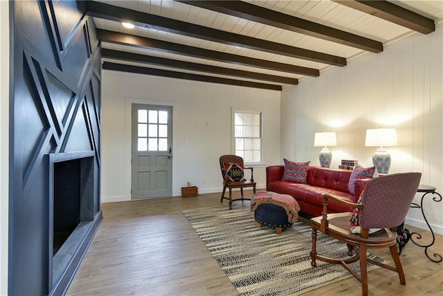 living room with beamed ceiling and light hardwood / wood-style flooring