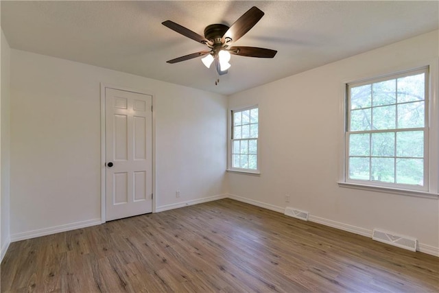 spare room with wood-type flooring and ceiling fan