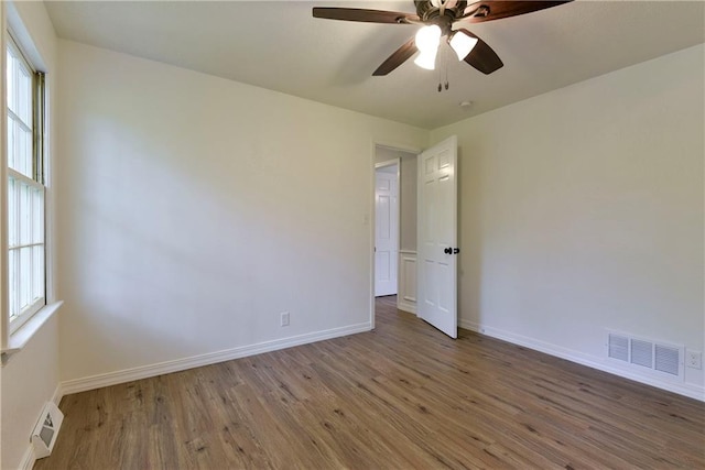 empty room with ceiling fan and dark hardwood / wood-style floors