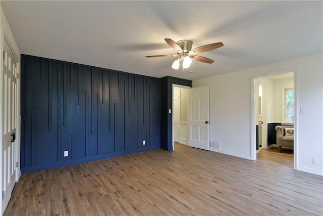 unfurnished bedroom with ceiling fan and light hardwood / wood-style floors