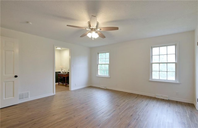 spare room with ceiling fan, a textured ceiling, and light hardwood / wood-style floors