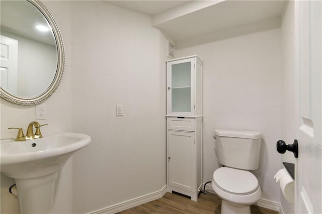 bathroom with sink, hardwood / wood-style floors, and toilet