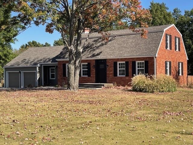 view of front of house with a garage and a front lawn