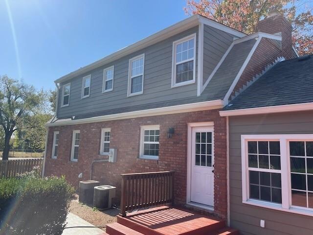 rear view of property with cooling unit and a wooden deck